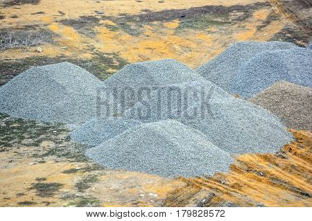Pieces of crushed stone piled in heaps at construction site