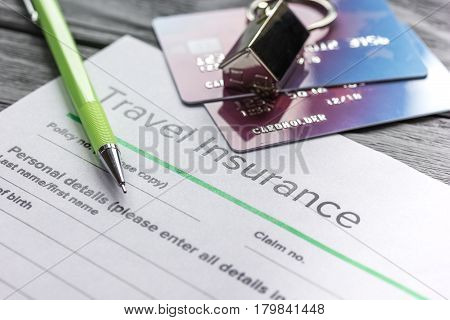Travel insurance application form with credit cards on gray wooden desk background