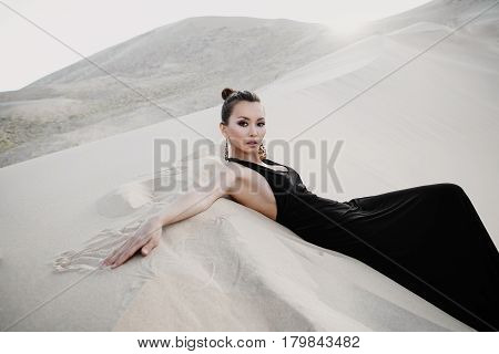 Woman in a black dress in desert