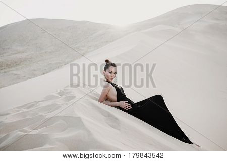 Woman in a black dress in desert