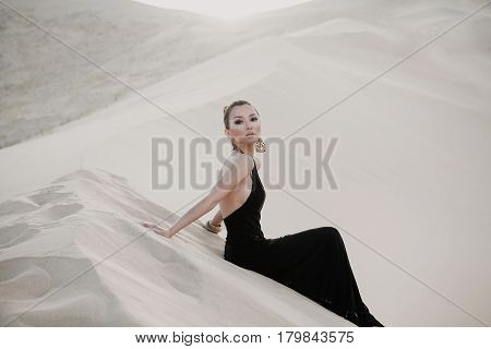 Woman in a black dress in desert