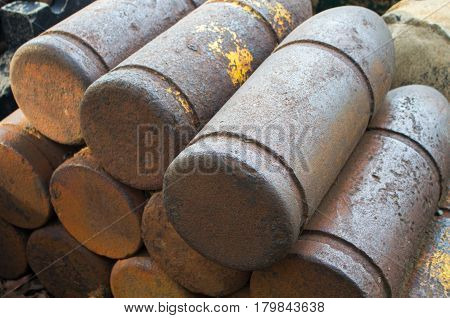 Medieval bombs with patina. Iron shell of cannon balls. Historical military ammunition. Unused cannon balls pile. Stack of rustic cannon shells. Military object. Unexploding war missile of XIX century