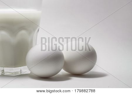 A glass of milk on a white background eggs