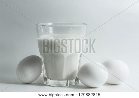 A glass of milk on a white background eggs