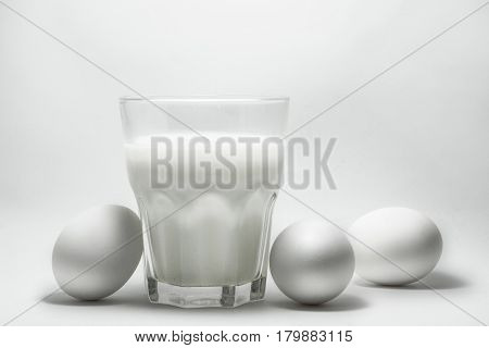 A glass of milk on a white background eggs
