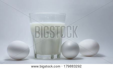 A glass of milk on a white background eggs