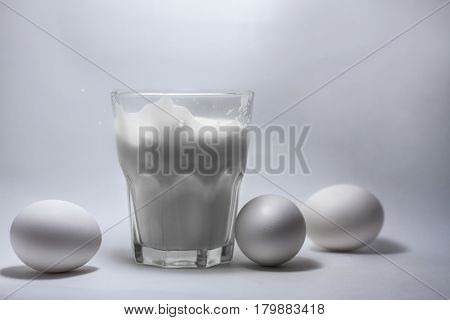 A glass of milk on a white background eggs
