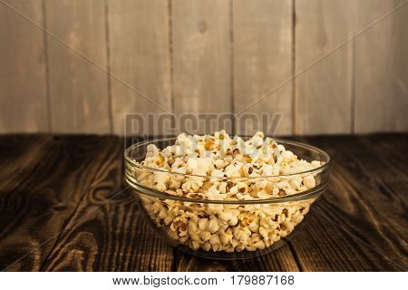 popcorn in the bowl on wooden background