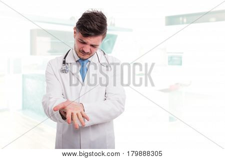 Young Doctor With Wrist Pain In Clinic Office