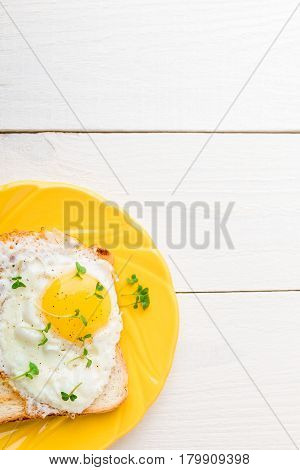 Toast With Egg In Yellow Plate With Micro-greenery On White Wooden Background. Healthy Breakfast. To