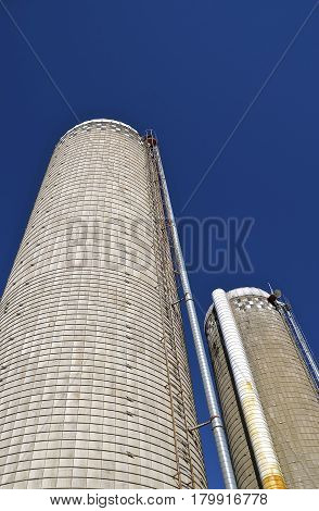 Two tall concrete state silos reach sign into the sky