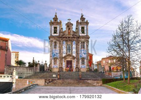 Beautiful old church of Saint Ildefonso or Igreja de Santo Ildefonso in a proto-Baroque style with facade covered with azulejos tiles in the sunny morning, Porto, Portugal