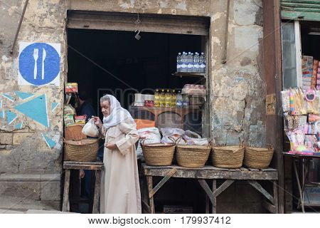 CAIRO, EGYPT - JANUARY 23, 2016: A traditional small shop and customer in traditional clothes in Capital City Cairo, Egypt.