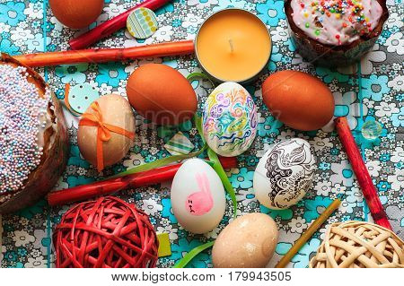 Painted easter eggs on blue flowers background in rustic style. Easter concept.