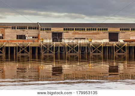 Old Wooden Harbor Buildings in Delfzijl under orange evening light