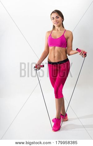 Woman In Sportswear Holding A Rope In His Hands. White Background. Studio.
