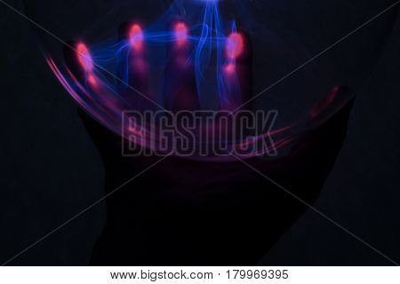 In the background is the hand that was illuminated by plasma from plasma lamp.