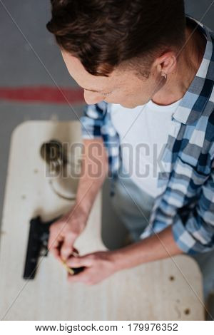 Skilled marksman. Top view of a nice pleasant professional marksman and putting bullets into the cartridge clip while reloading his handgun