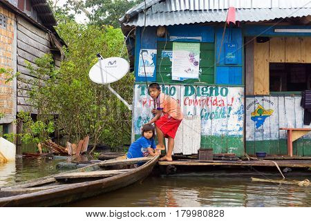 IQUITOS PERU - MARCH 17: Children with a canoe on the river in Iquitos Peru on March 17 2015