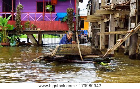IQUITOS PERU - MARCH 17: Elderly man fixes a canoe in Iquitos Peru on March 17 2015