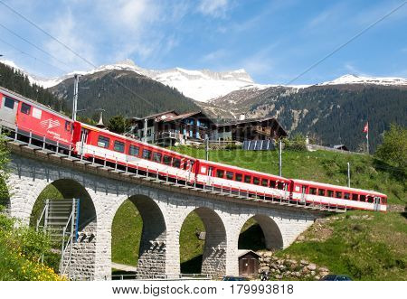 Surselva Switzerland - May 14 2015: Bridge of the Rhaetian Railway in the Surselva valley. The deck is illuminated by the sun during a beautiful day on the day of the Feast of the Ascension.