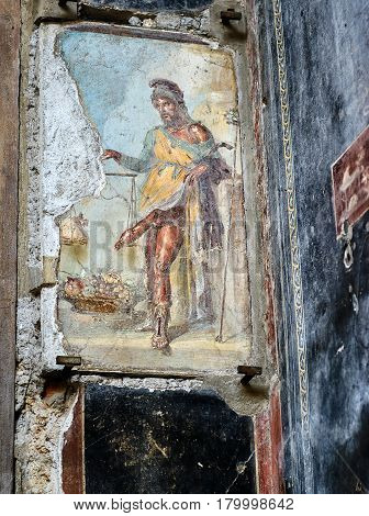 POMPEII, ITALY - MAY 13, 2014: Antique fresco depicting the god Priapus with large phallus. Pompeii is an ancient Roman city died from the eruption of Mount Vesuvius in 79 AD.