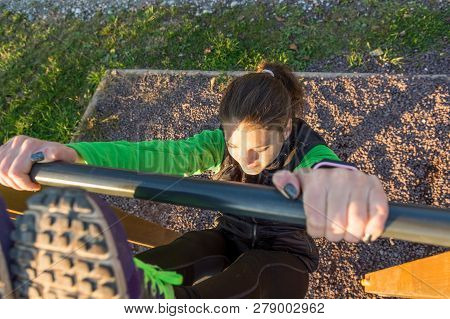 Athletic Female Doing Exercise At Outdoor Fitness Pullup Bar Station.
