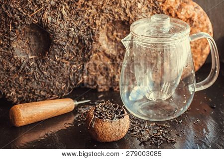 Puer Raw Tea. Pu-erh Cakes, Orange Tea, Knife And Teapot For Ceremony. Traditional Chinese Beverage 