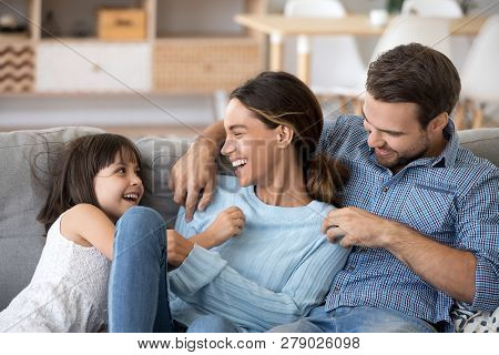 Kid Daughter And Dad Tickling Mom Having Fun Playing Together