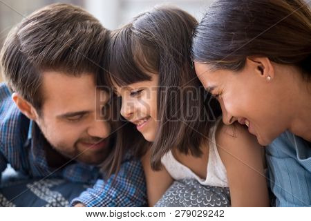 Affectionate Family Parents And Cute Child Daughter Bonding Tend