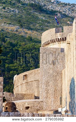 The Fortress Of Dubrovnik Old Town And The Minceta Tower With Croatian National Flag.