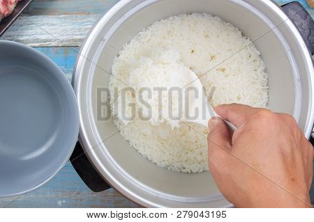 Chef Put Cooked Rice With Plastic Ladle To Cup In Electric Rice Cooker