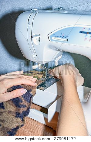 Sewing Process - Close Up Woman`s Hands At Work With Sewing Machine. Seamstress Occupation Concept.