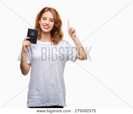 Young beautiful woman holding passport of australia over isolated background surprised with an idea or question pointing finger with happy face, number one