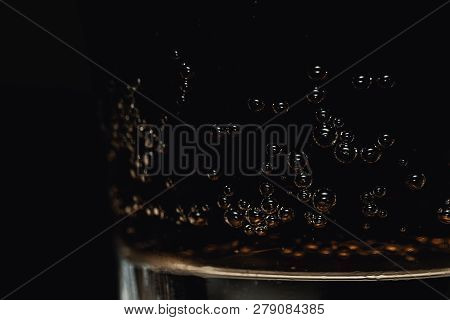 Refreshing Glass Of Cola Fizzy Drink With Bubbles On Black Background