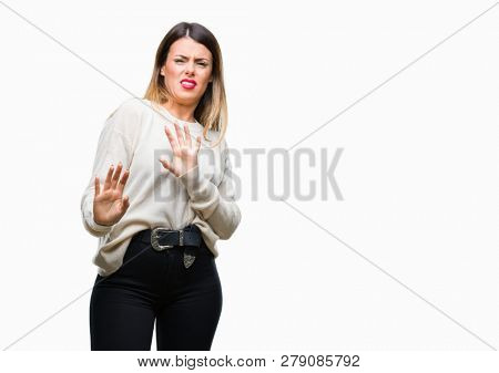 Young beautiful woman casual white sweater over isolated background disgusted expression, displeased and fearful doing disgust face because aversion reaction. With hands raised. Annoying concept.