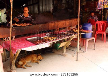 Siem Reap, Cambodia - Mart 25, 2018: Unhurried Cambodian Life. Cooking Local Cuisine On Grill And Ba