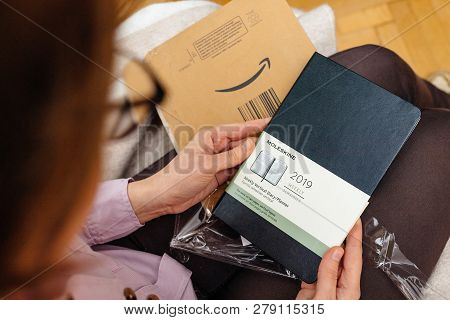 Paris, France - Jan 7, 2018: Woman Unboxing Admiring New Moleskine Weekly Vertical Diary In Her Livi