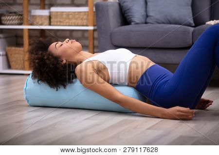 Close-up Of A Young African Woman Lying On Pillow Exercising