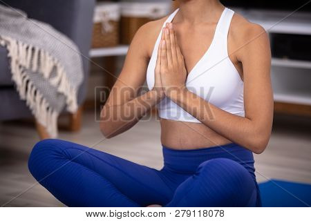 Young African Woman Sitting On Floor In The Prayer Position Mediating