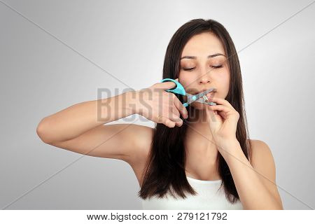 Stop Smoking Concept. Young Woman Cut Cigarettes With Scissors Happy Smiling. Focus On Hand, Scissor