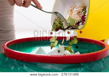 Woman Throwing Vegetables In Trash Bin