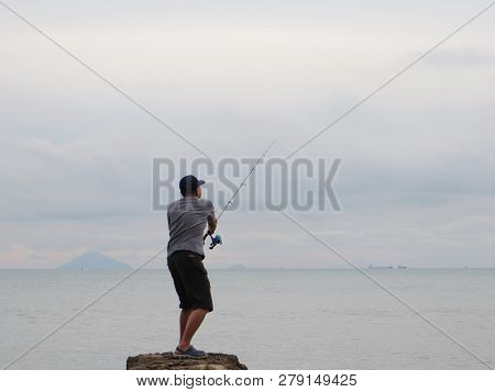 Anyer, Indonesia - June 25, 2018: A Man Arranged His Fishing Line On The Edge Of The Sea.