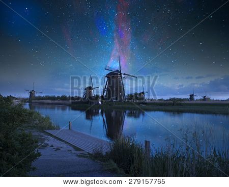 Night Field Of Tulips And Windmill. Landscape With Stars And Flowers. Traditional Holland View
