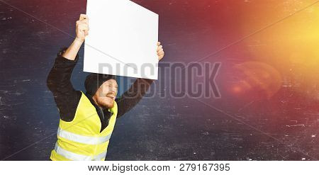 Protests Yellow Vests. Young Man Is Holding A Poster With Light. The Concept Of Revolution And Prote
