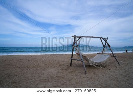 Empty Hammock Strung Between Two Wooden Pile On The Sandy Beach. Royalty High-quality Stock Photo Im