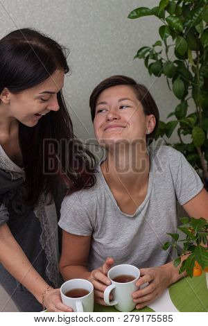 Girl Friends Laugth While Having Breakfast. Short Brown Hair Woman And Dark Long Hair Woman With Mor