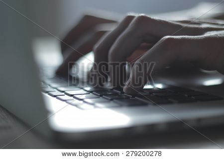 Blurred Image Of Male Hand Typing On Laptop Keyboard.close Up