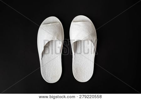 Pair Of White House Slippers On Black Background. Top View Of Disposable Slippers In Dark Contrasty 