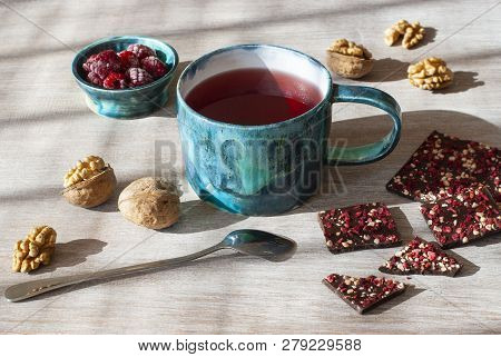 Raspberry Tea, Chocolate, Nuts And Raspberries On A Wooden Table, Selective Focus.